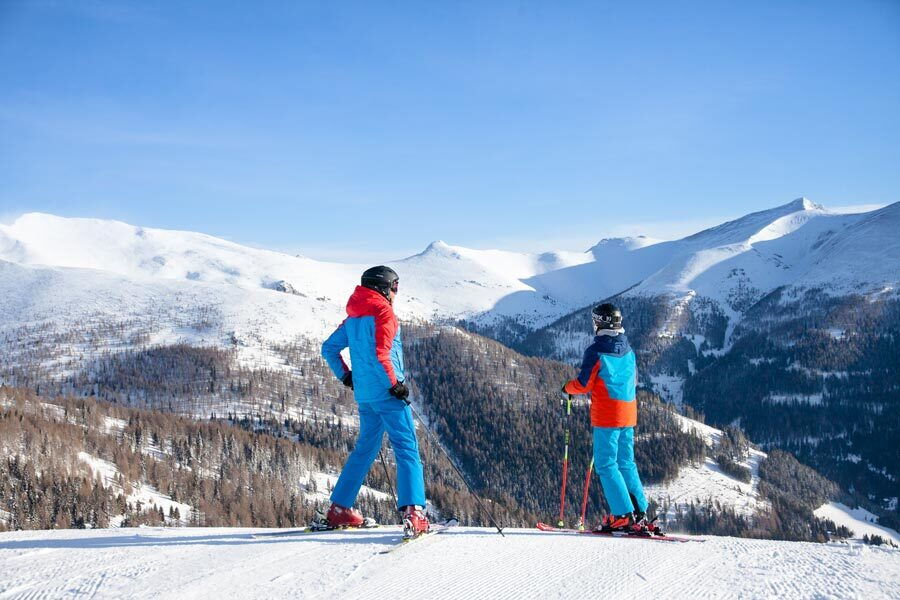 Father and son skiing on a piste in the Carinthian Alps